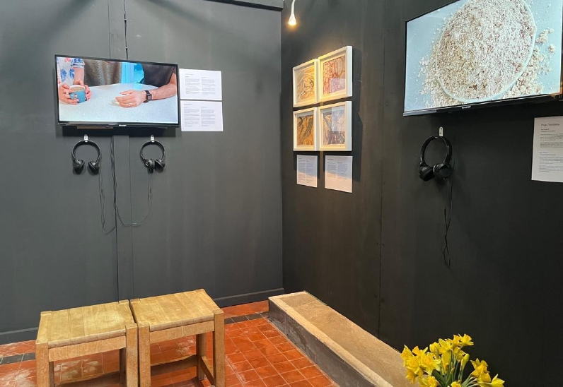 Black walls with screens displaying art work